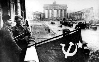 Al fondo, la puerta de Brandemburgo, mientras los soldados soviéticos ondean su bandera después de la batalla de Berlín, en mayo de 1945.